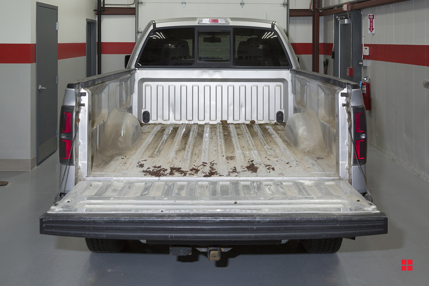 A dirty and worn metal truck bed that hasn’t been coated. 